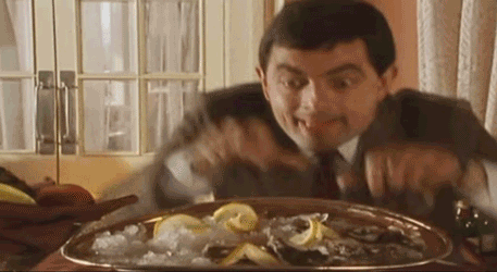 A man sneakily loading oysters onto 2 dinner plates.